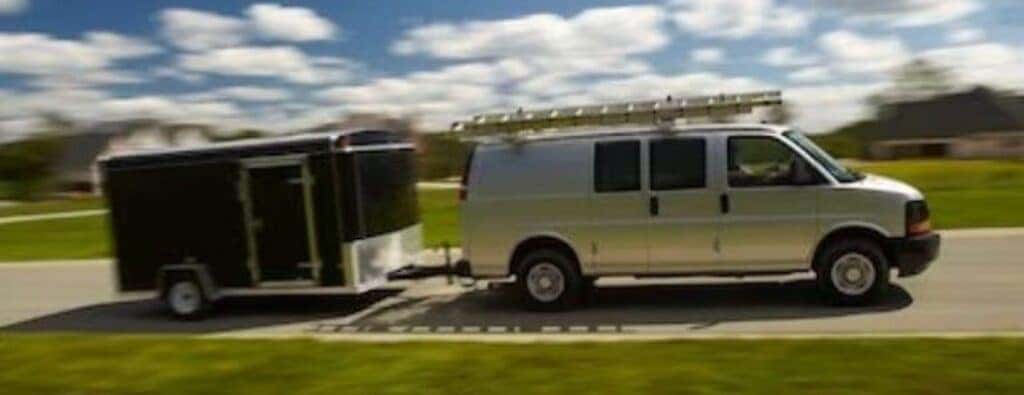 2024 Chevrolet Express van side view with a trailer and ladder