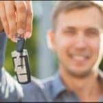 a man holding up a car key