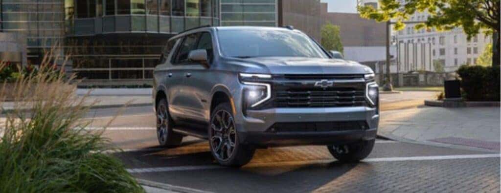 2025 Chevrolet Tahoe front view on a road through a forest