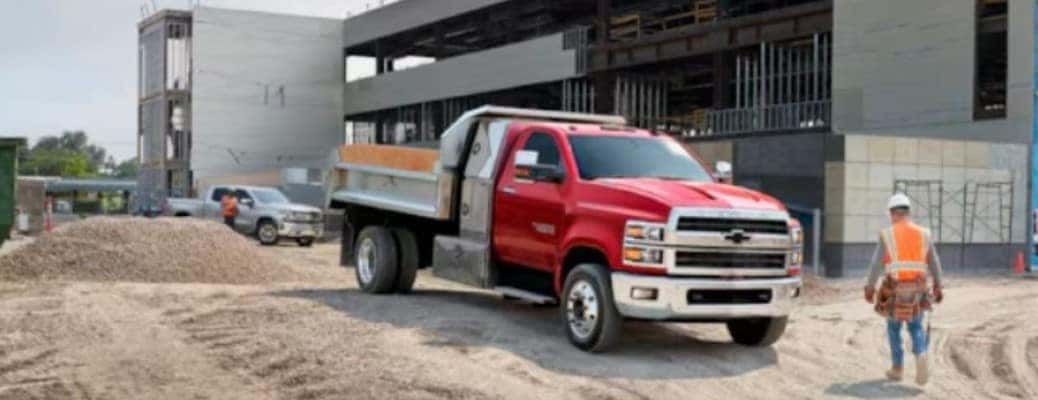 red Chevrolet medium-duty truck at a work site