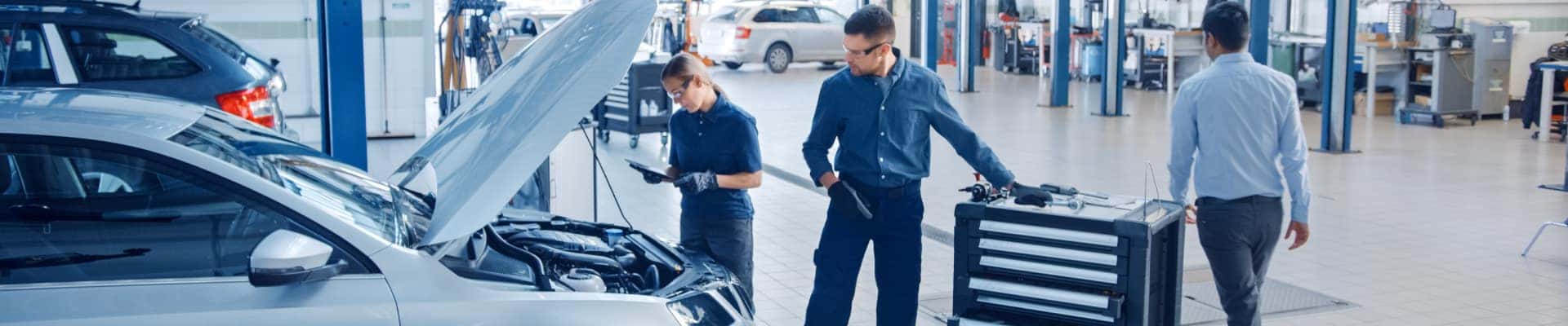 Two technicians working on an engine bay