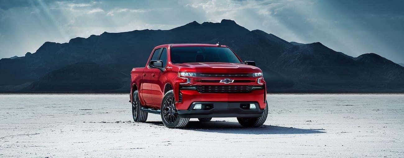 Red 2019 Chevy Silverado in salt flat with mountain in back