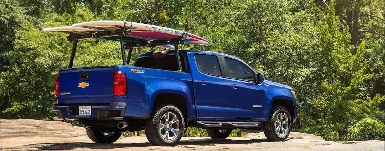 A bright blue 2019 Chevy Colorado parked at an empty beach for windsurfing