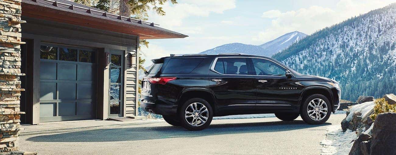 A black Traverse stands victorious against snow-covered mountains having won 2019 Chevy Traverse vs 2019 Jeep Grand Cherokee