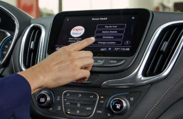 hand touching a screen in a Chevrolet vehicle