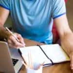 a torso with a laptop and a notebook