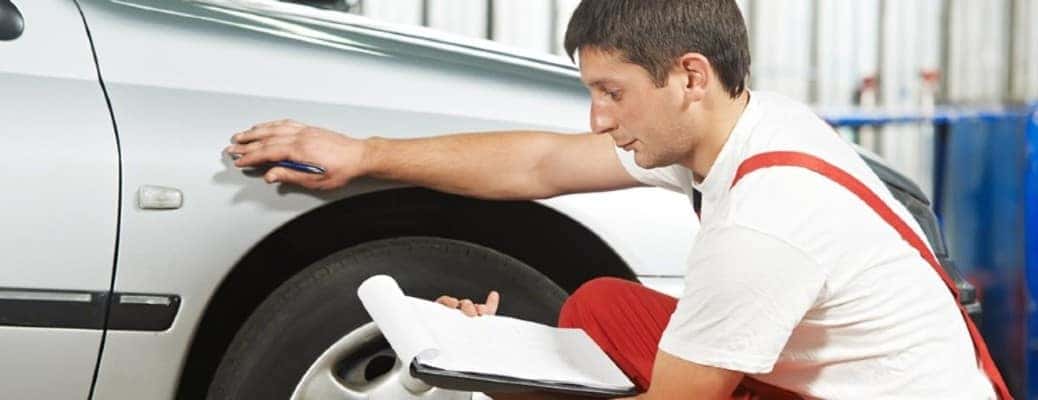 a man inspecting a vehicle's tires