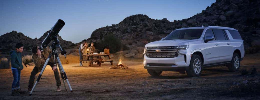 A family having a good time camping outside their Chevy Suburban.