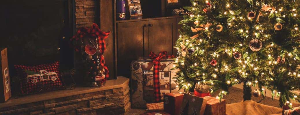 A decorate Christmas tree near a fireplace.