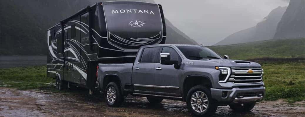The 2024 Chevy Silverado 2500 HD high-tech pickup truck towing a large trailer.