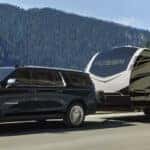 The 2024 Chevy Suburban towing a large camper trailer.