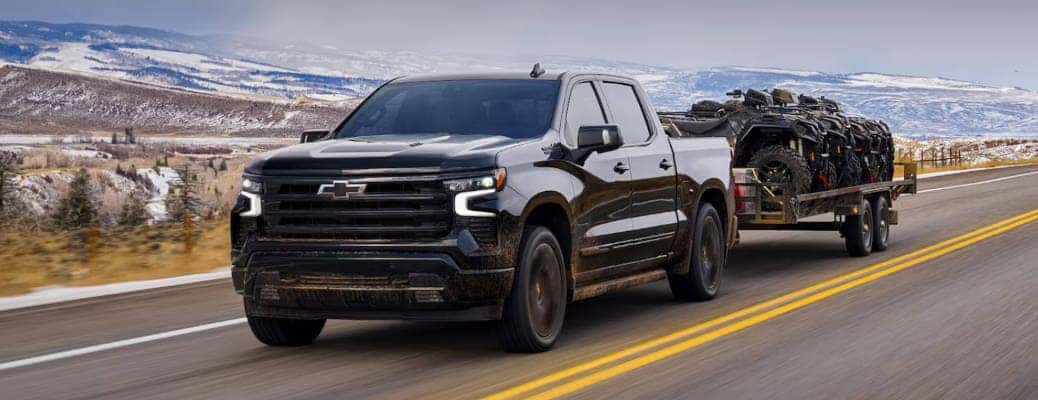 The 2024 Chevy Silverado 1500 towing a large trailer.