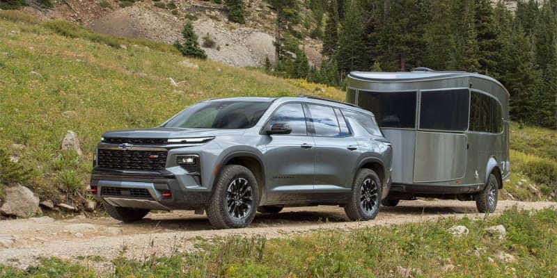 A front quarter view of the Chevy Traverse towing a trailer.