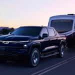 The 2025 Chevy Silverado EV towing a large camper trailer.
