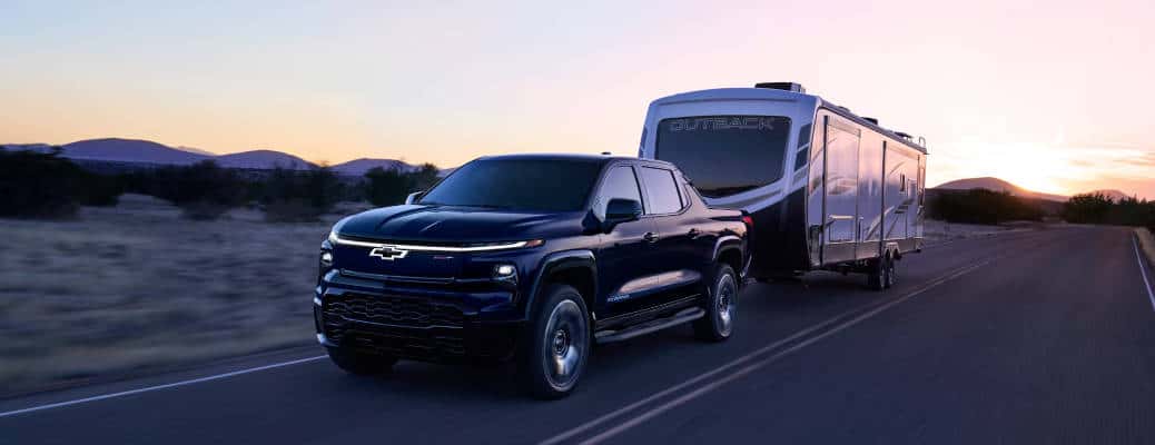 The 2025 Chevy Silverado EV towing a large camper trailer.