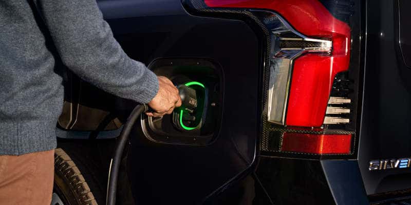 A man charging the Chevy Silverado EV.