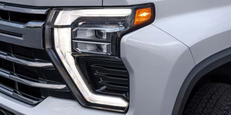 A detail of the front headlamp assembly on the 2025 Chevy Silverado 3500 HD.