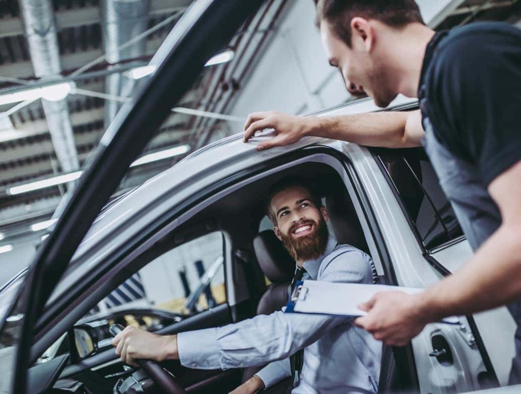 Service advisor discussing vehicle maintenance with a customer inside a service center.