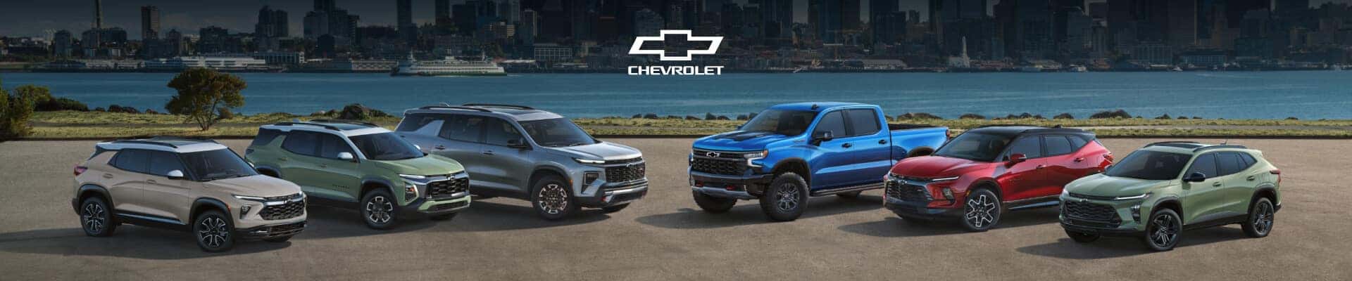 2026 Chevrolet SUVs lineup and Silverado pickup in assorted colors, parked by a waterfront city skyline