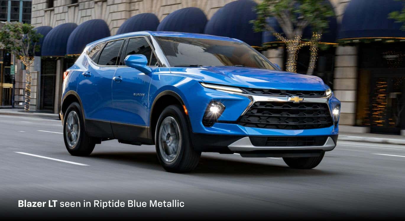 2026 Chevrolet Blazer LT in Riptide Blue Metallic, front three-quarter passenger-side view driving on a city street.