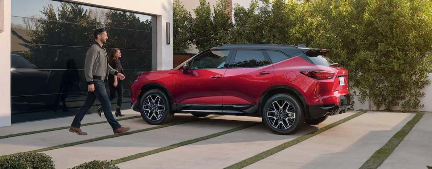 A red 2025 Chevy Blazer RS is shown parked near a garage.