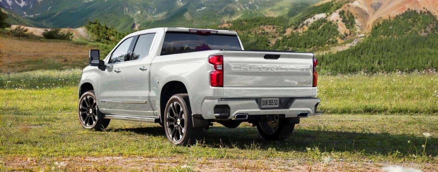 A white 2025 Chevy Silverado 1500 for sale is shown from the rear at an angle.