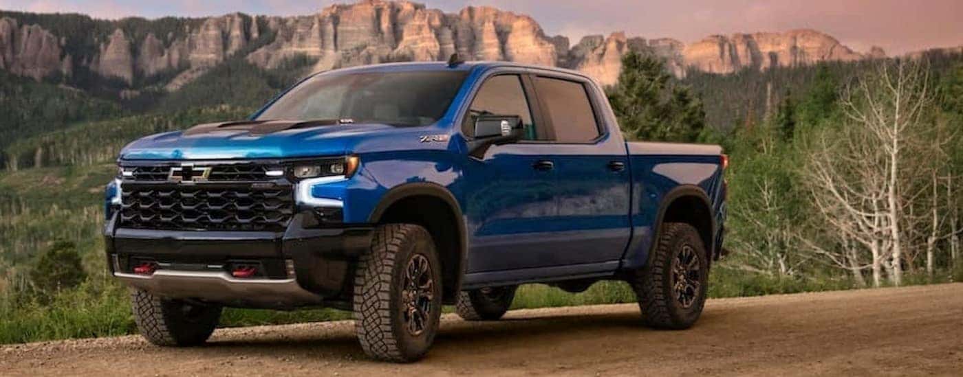 A blue 2024 Chevy Silverado 1500 ZR2 is shown parked off-road.