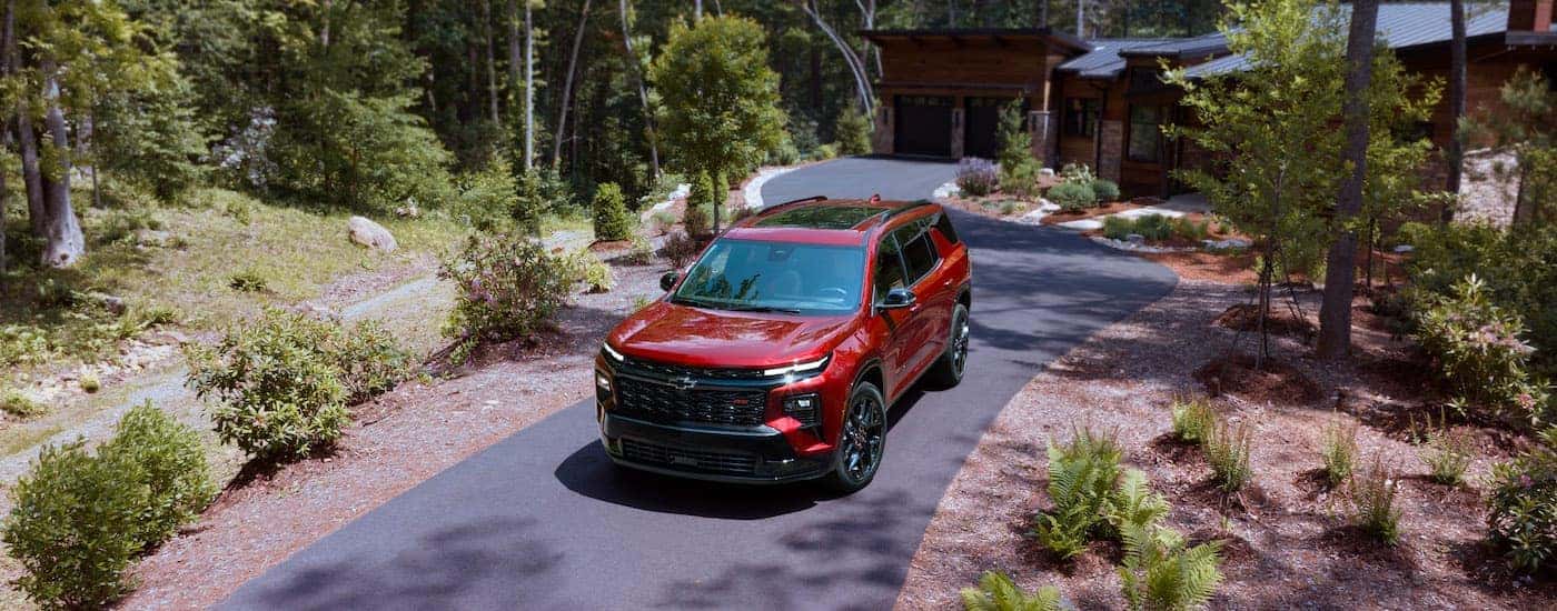 A red 2025 Chevy Traverse RS is shown from the front at an angle.