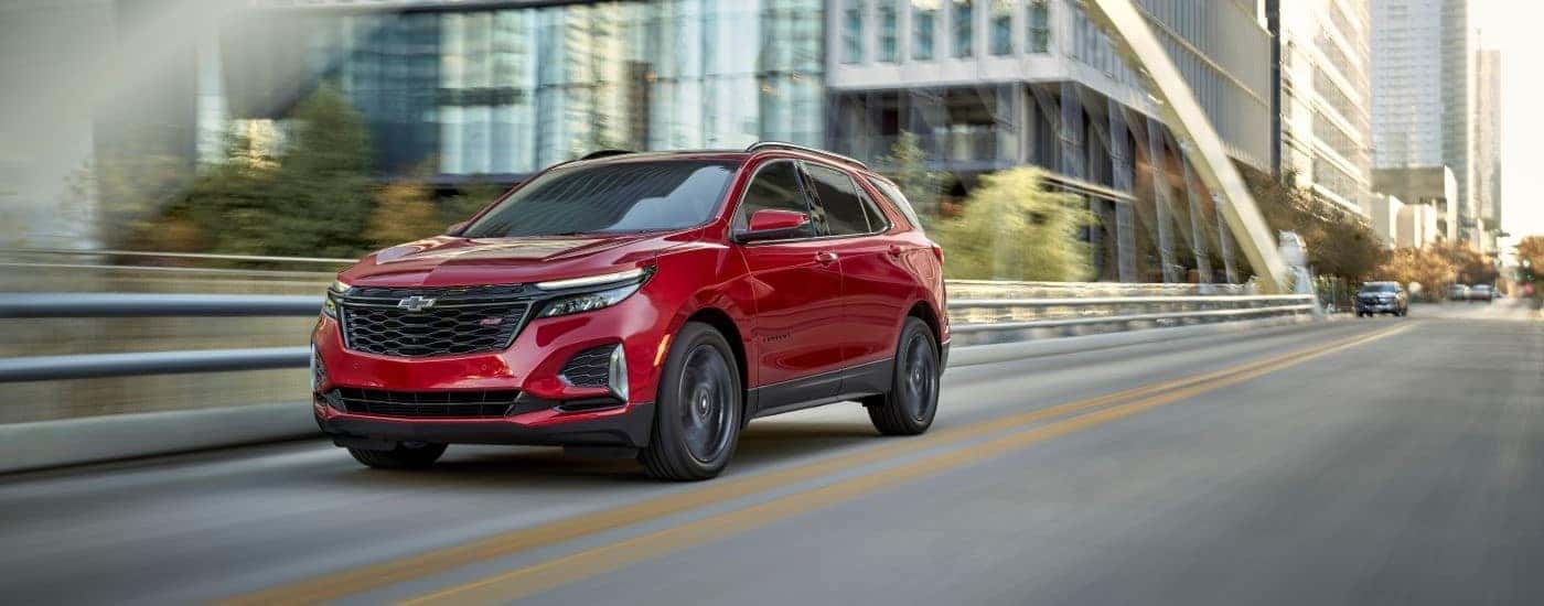 A red 2024 Chevy Equinox RS driving over a bridge.