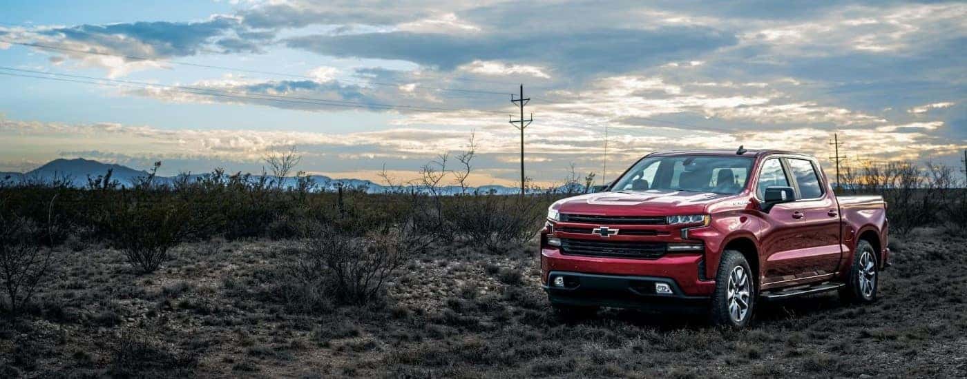 A red 2023 Chevy Silverado 1500 RST parked in a field.
