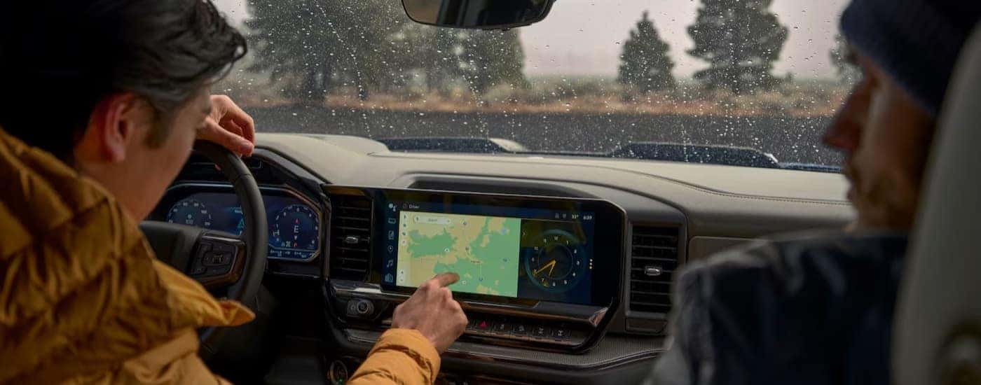 A person using the infotainment screen in a 2025 Chevy Silverado 1500 for sale near Coventry.