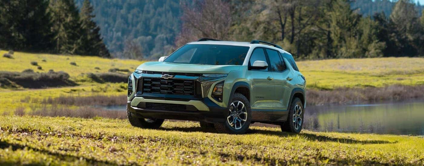 A green 2025 Chevy Equinox ACTIV is shown parked on grass after visiting a Chevrolet dealer near East Hartford.