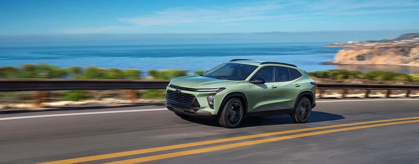 A green 2025 Chevy Trax for sale near Manchester driving down a highway