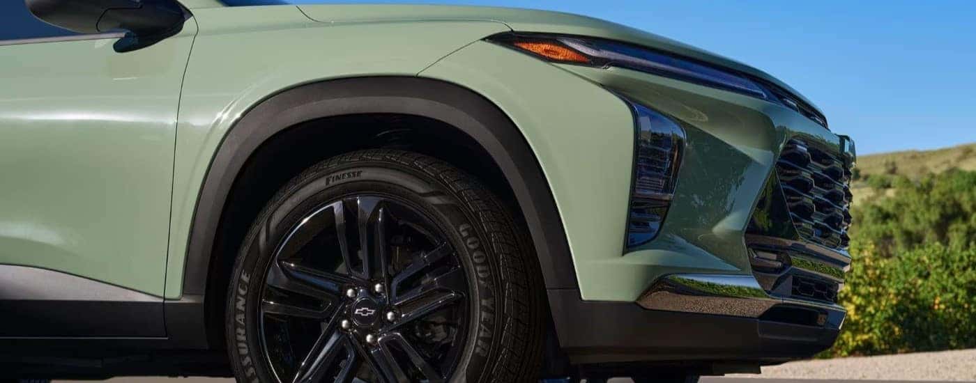 Black rim and tire on a green 2024 Chevy Trax parked