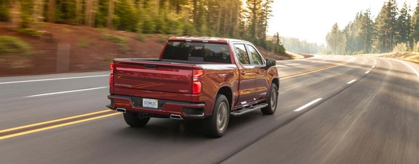 A red used 2021 Chevy Silverado 1500 for sale in Vernon driving on a highway