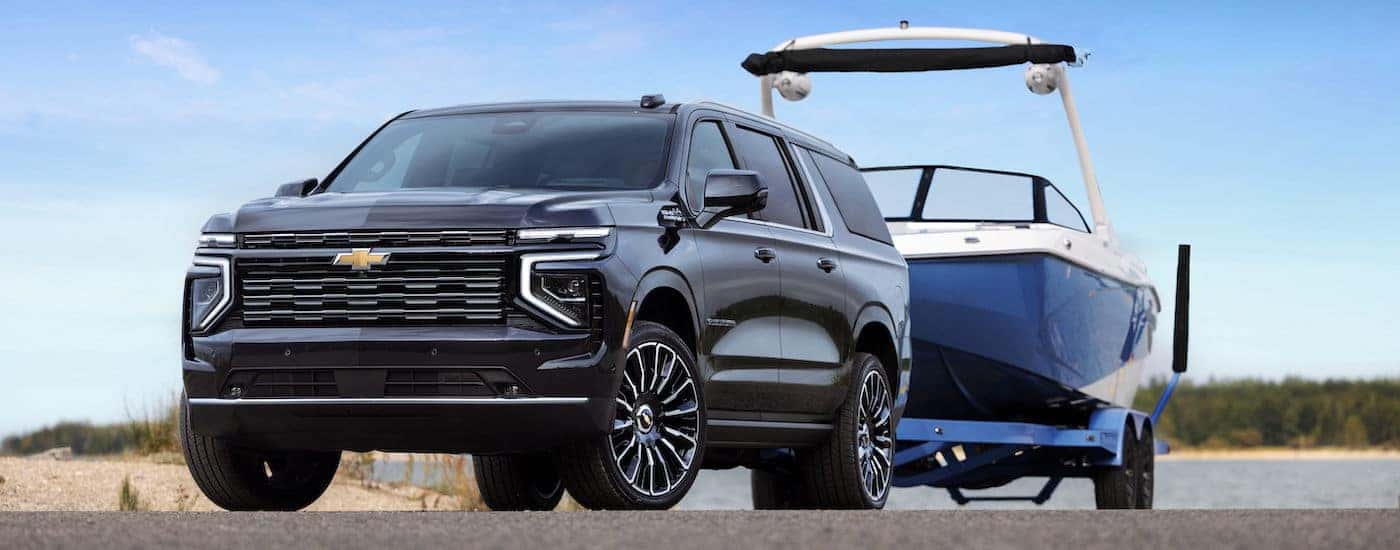 Black 2025 Chevy Suburban towing a boat from a Chevy dealer near Rockville.