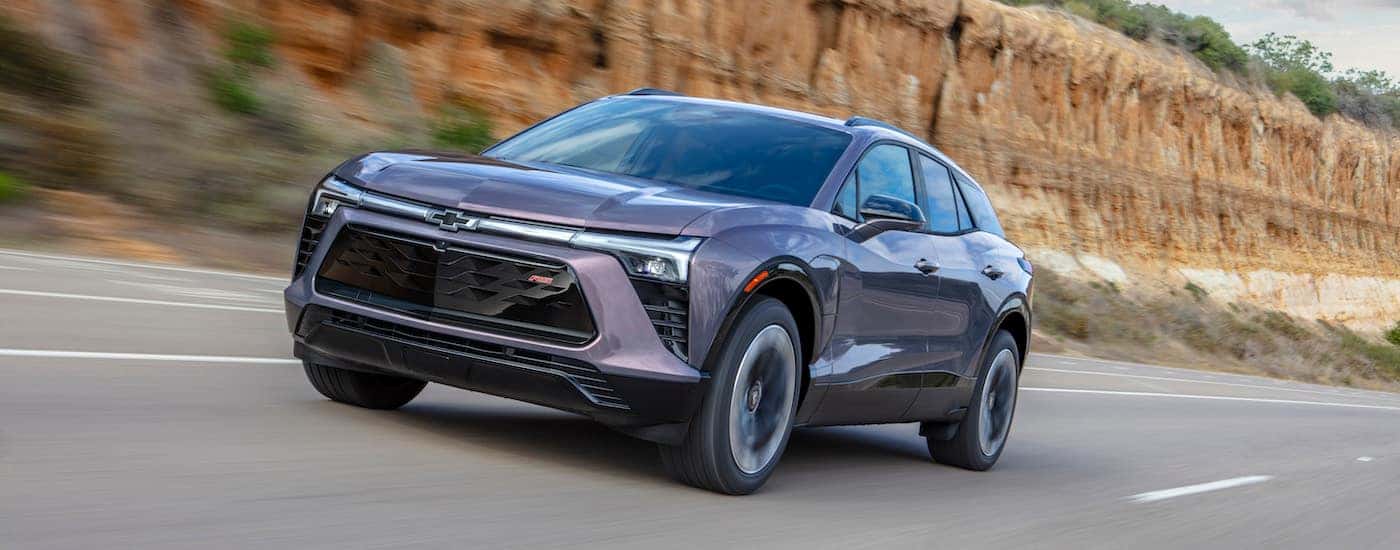 A grey 2025 Chevy Blazer EV from the front at an angle after leaving a dealer that has a Chevy EV for sale.