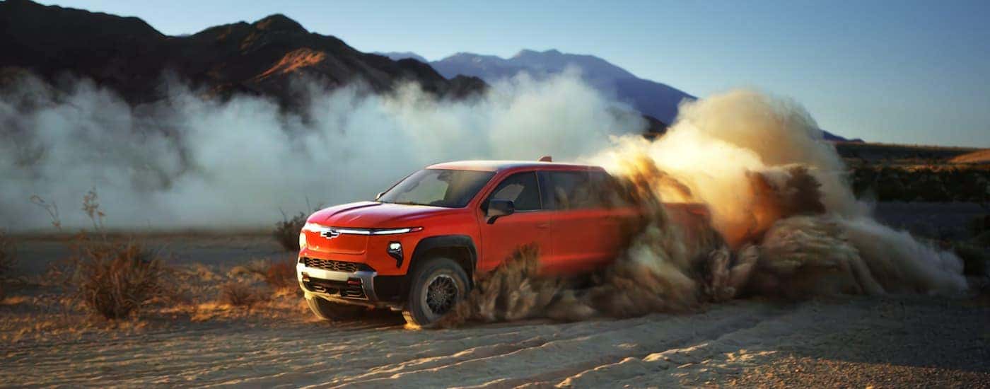Red 2025 Chevy Silverado EV driving off-road.