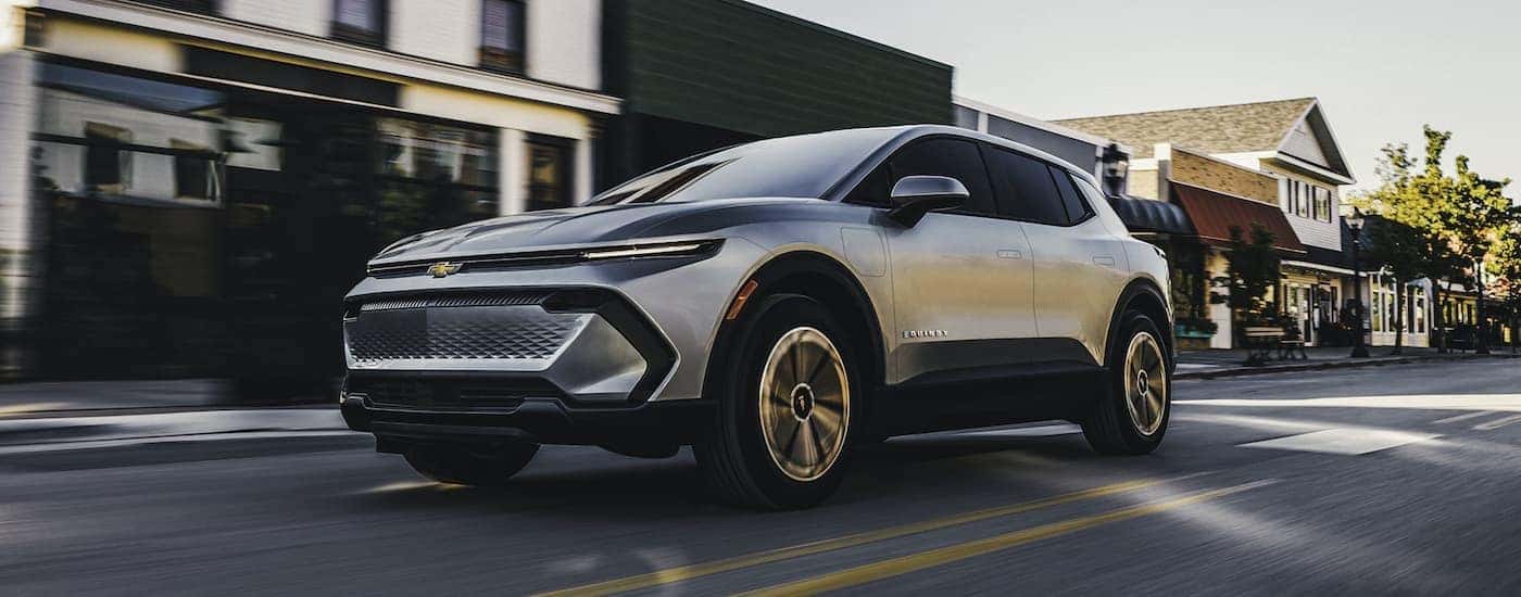 White 2026 Chevy Equinox EV driving through a city.