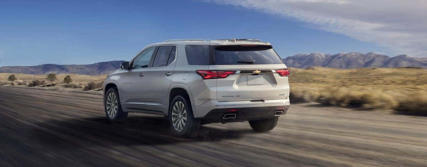 White 2022 Chevy Traverse driving down an empty road