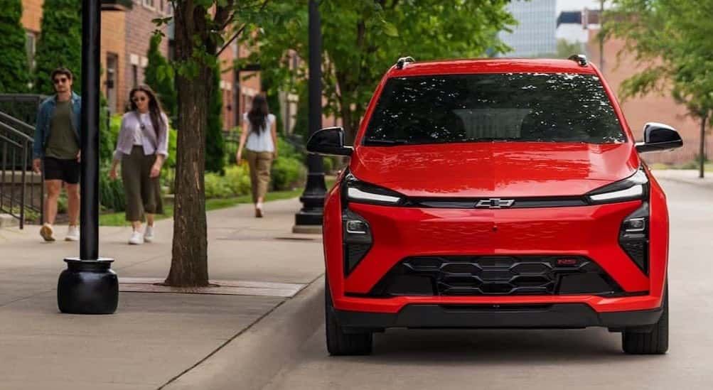 A red 2027 Chevy Bolt RS parked in a city.
