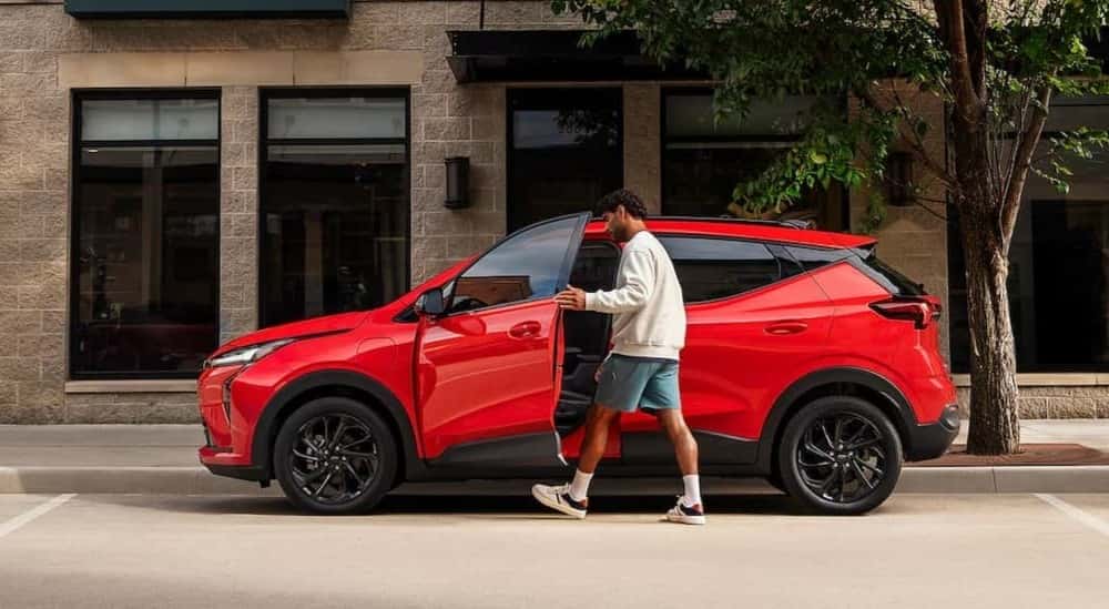 A red 2027 Chevy Bolt parked in a city.