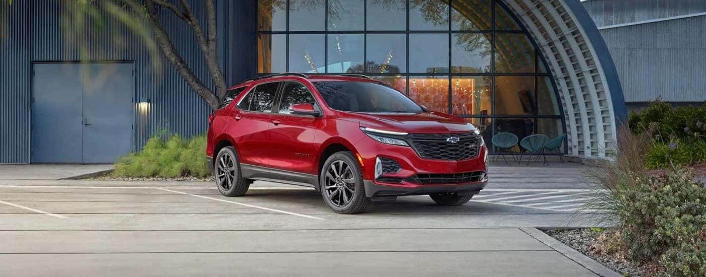 A red 2024 Chevy Equinox RS parked outside a building