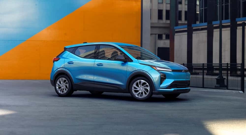 A blue 2027 Chevy Bolt parked in a city