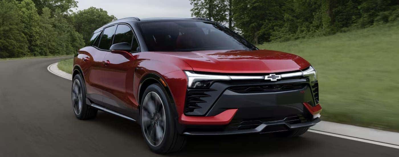 A red 2026 Chevy Blazer EV driving down a road