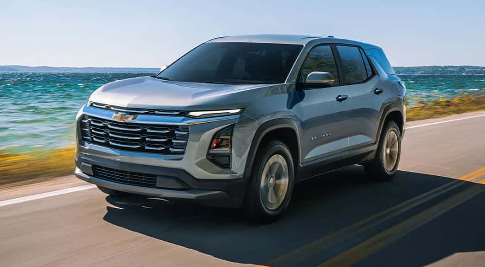 Grey 2026 Chevy Equinox driving down a road along the water