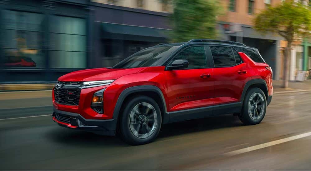 Red 2026 Chevy Equinox driving down a city street