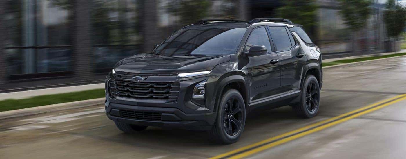 Black 2026 Chevy Equinox driving on a city road.