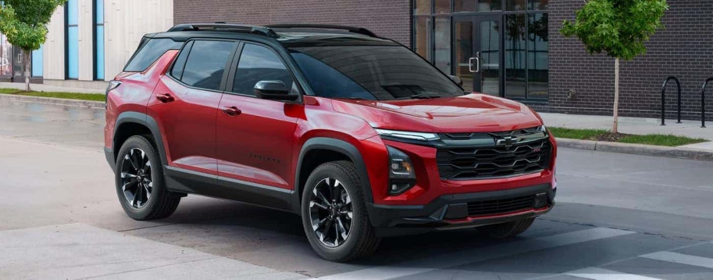 A red 2025 Chevy Equinox RS driving over a crosswalk.