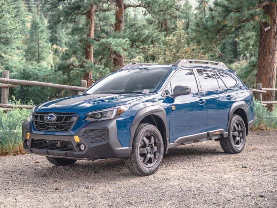 Blue Subaru driving through muddy puddles. 